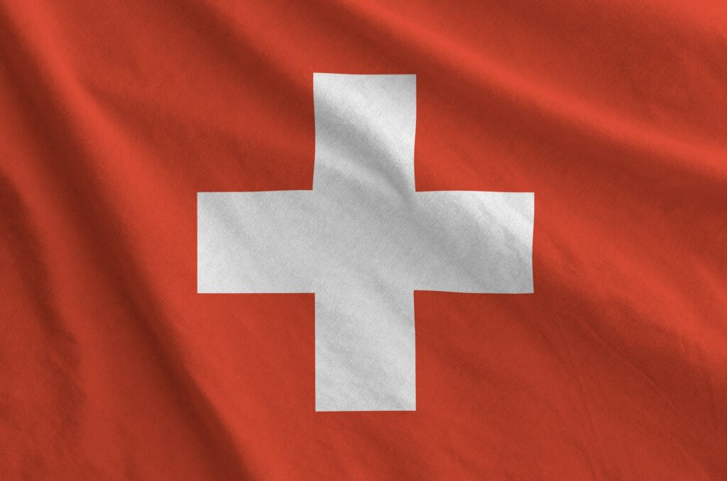 Switzerland flag depicted on folded wavy fabric of old cloth